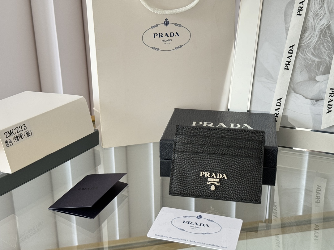 Prada 经典款男士卡 片夹专柜官网 同 步 正 品开 发 编号 2MC223 意大 利 顶 级原单 十 字纹牛 皮质 感极 好 进 口 螺纹里 布 进 口环 保油边  进口 钢 五金 配件 走线 做 工精湛 完美 品 质媲 美正 品  这 款 Saffiano皮革 卡片夹 以 标志 性 的 涂珐 琅 金属 贴花装 饰  开启 奇思 妙想 的 时尚之 旅 饰 有一枚 同色 刻 字徽 标 彰显 匠心 品质      尺 寸 长 10cm高 8cm