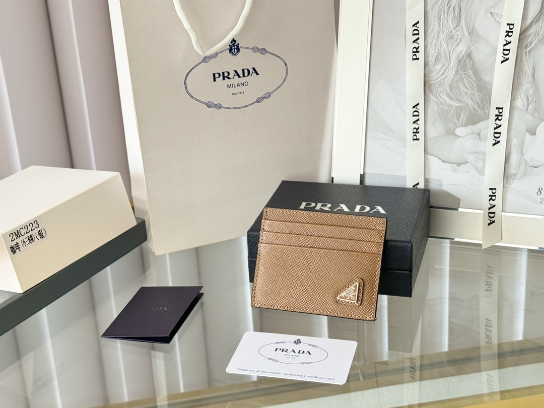Prada 经典款男士卡 片夹专柜官网 同 步 正 品开 发 编号 2MC223 意大 利 顶 级原单 十 字纹牛 皮质 感极 好 进 口 螺纹里 布 进 口环 保油边  进口 钢 五金 配件 走线 做 工精湛 完美 品 质媲 美正 品  这 款 Saffiano皮革 卡片夹 以 标志 性 的 涂珐 琅 金属 贴花装 饰  开启 奇思 妙想 的 时尚之 旅 饰 有一枚 同色 刻 字徽 标 彰显 匠心 品质      尺 寸 长 10cm高 8cm