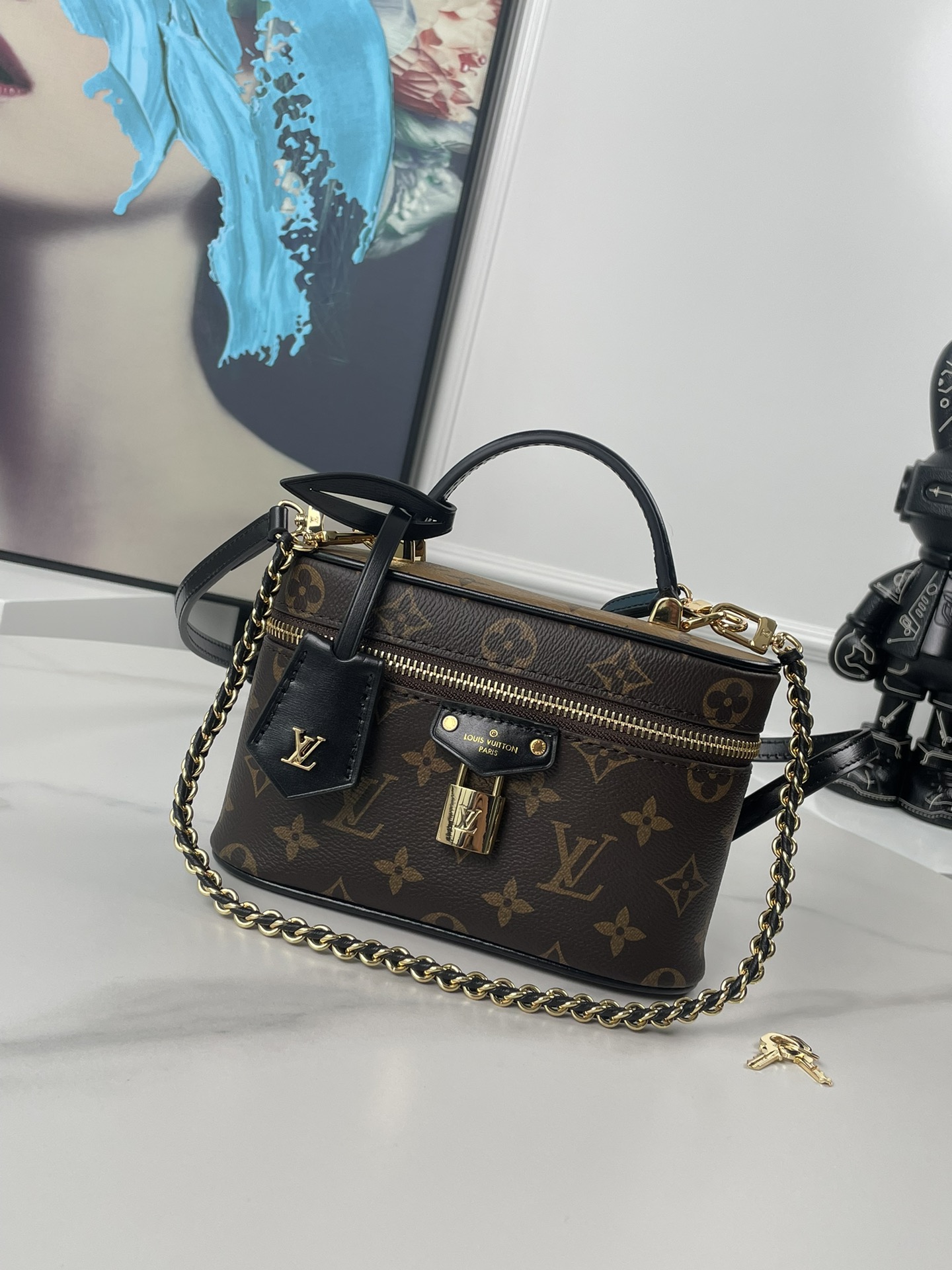 原单M47125独家实拍  Vanity Chain Pouch 手袋向经典化妆箱汲取灵感 以 Monogram 帆布诠释旅行精神 顶部手柄和可拆卸编织链条融入皮革元素 与包身的简明线条相互映衬 LV 铭纹挂锁和皮革钥匙包延续标志性细节 尺寸 19 11.5 6.5cm