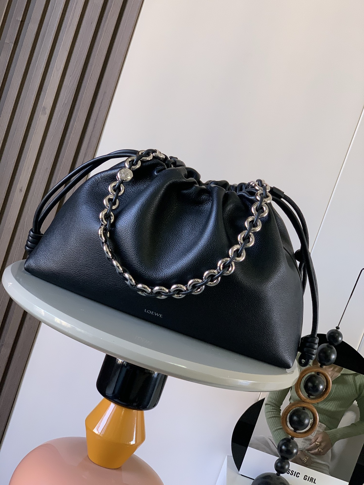 新款 大号鹿皮革 Flamenco Purse 手拿包 Flamenco Purse 采用褶皱设计 侧面搭配标志性绳结此大号版本采用鹿皮革制成   可肩背 斜挎或手提 可拆卸可调节皮革肩带 耐磨耐造又软又有光泽 可拆卸甜甜圈链条 饰有 Anagram Pebble  磁扣开合 绒面革衬里  LOE WE 烫银 尺寸 41cm 9cm 26cm颜色 黑色鹿皮款号 9088