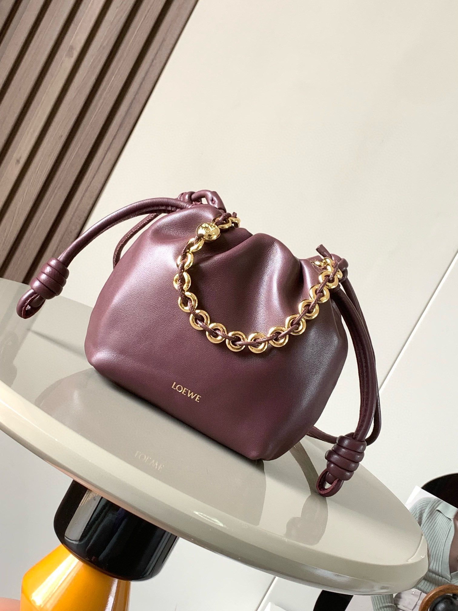   明星同款 迷你纳帕羊皮革 Flamenco Purse 新款手拿包 Flamenco Purse 手袋采用褶皱设计 侧面搭配标志性绳结等关键细节 款式时尚百搭 可作为手拿包携带 亦可搭配甜甜圈 链条肩背或搭配皮革肩带斜挎  此版本采用柔软纳帕羊皮革制成  可肩背 斜挎或手提 可拆卸可调节皮革肩带 可拆卸甜甜圈链条饰有 Anagram 镌刻卵石纹 低调的磁扣开合 绒面革衬里    LOEWE 烫金或烫银 款号 9058尺寸 23cm 17cm 5.5cm颜色 勃良地红