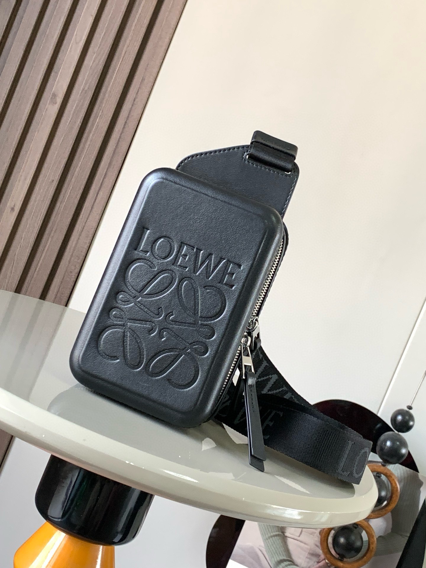  光滑牛皮革 Molded Sling手袋 Molded Sling是一款实用的斜挎包 配有LoEWE织带和可旋转的品牌标记滑块 使肩带能够贴合身体 此版本采用光滑牛皮革制成 *   可斜挎*  拉链开合 牛皮革拉链头*   两个内部隔层*  牛皮革衬里*   L0EWE Anagram 压纹尺寸 18.5CM 12.5CM 6.5CM款号 9117颜色 黑色