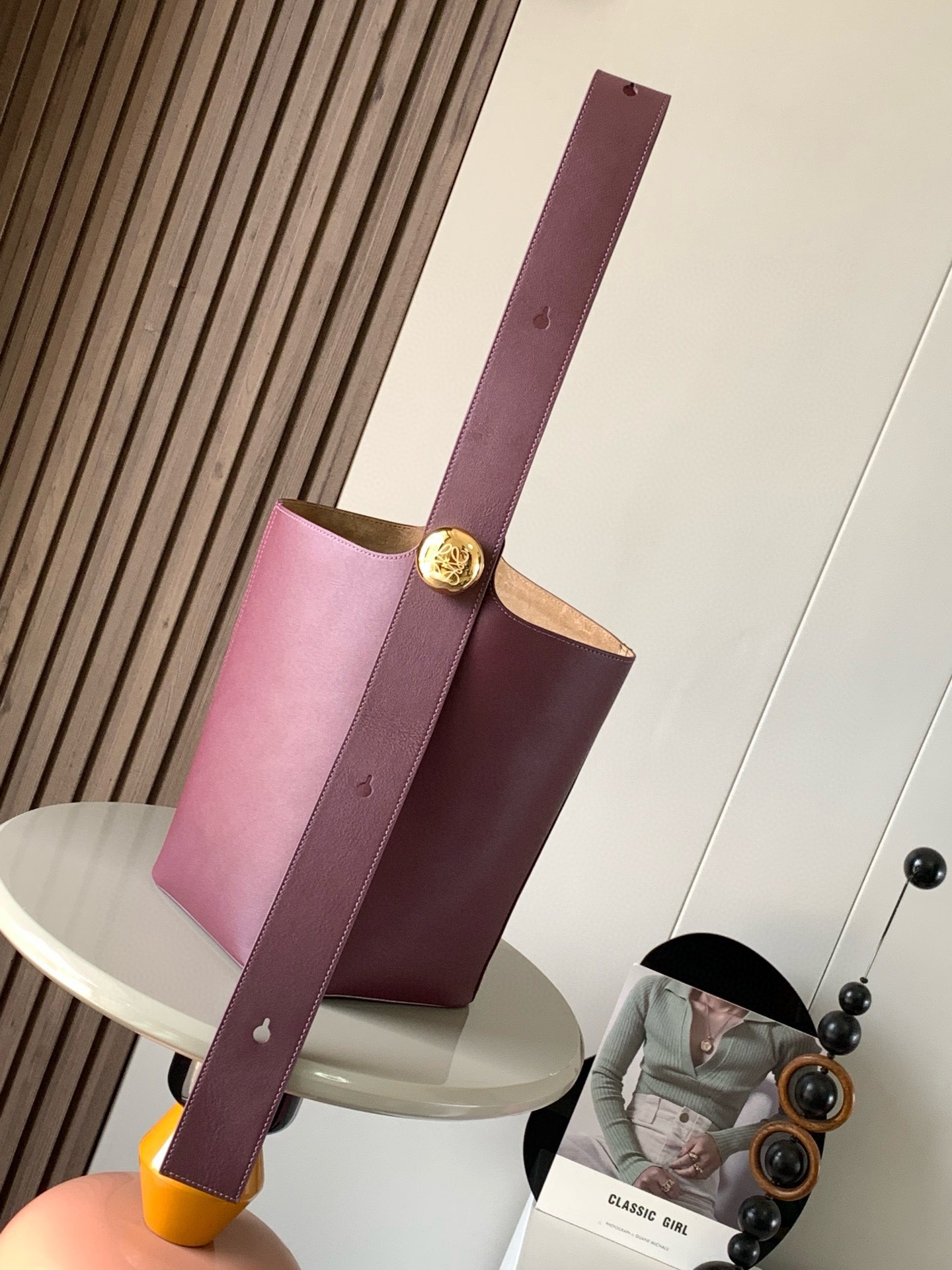 中号柔软牛皮革 Pebble Bucket 水桶包是 L0EWE极简主义的又一代表 水桶包时尚简约且能装  Anagram金色鹅卵石配件是点睛之笔这个包的一个特点是肩带很宽 所以它更适合斜挎 或者像秀场男模特那样 把包单拎在后背  尽显自在 当然 宽肩带是双开门的穿搭福利 单肩背法稳重利落 Pebble 将纯粹的简约线条与瞩目设计风格巧妙融合 造就别具一格的创新的手袋设计 标志性的 Anagram 雕刻五金件兼具装饰和实用功能 可调节肩带长度并适合多种携带方式 独特的扭曲结构与微妙的细节相得益彰  此中号版本采用柔软牛皮革制成 *可肩背或斜挎*可调节肩带*磁扣开合*内袋 合成革衬里 *Anagram 雕刻卵石 尺寸 28CM 24CM 23CM款号 9045颜色 酒红色