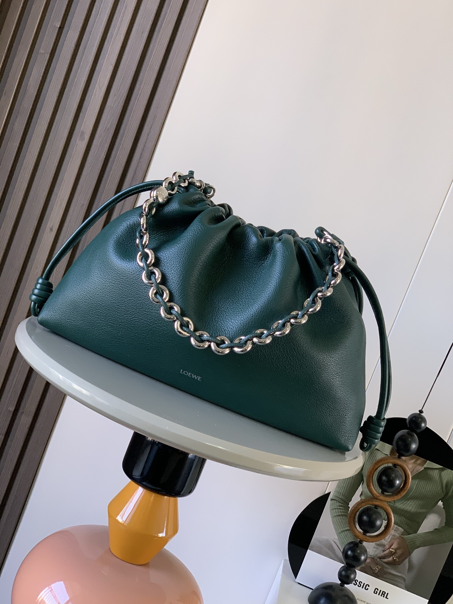 新款 大号鹿皮革 Flamenco Purse 手拿包 Flamenco Purse 采用褶皱设计 侧面搭配标志性绳结此大号版本采用鹿皮革制成   可肩背 斜挎或手提 可拆卸可调节皮革肩带 耐磨耐造又软又有光泽 可拆卸甜甜圈链条 饰有 Anagram Pebble  磁扣开合 绒面革衬里  LOE WE 烫银 尺寸 41cm 9cm 26cm颜色 常青绿鹿皮款号 9088