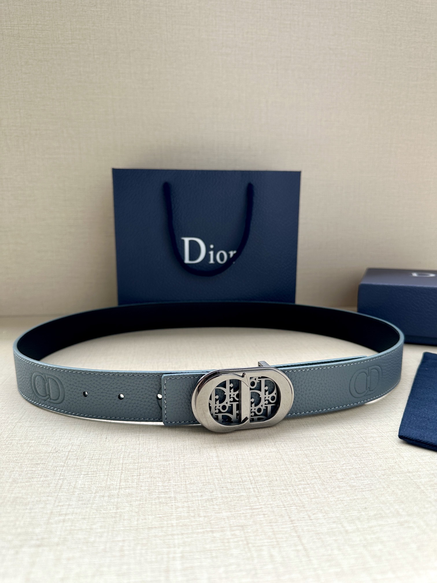 Dior 这款 35毫米双面腰带结合典雅气质与摩登风范 一面则采用迪奥灰粒面牛皮革 另一面则采用同色调压花 CD Icon 标志 长度可调节 可搭配各式 35毫米腰带扣 压花 CD Icon 标志粒面牛皮革