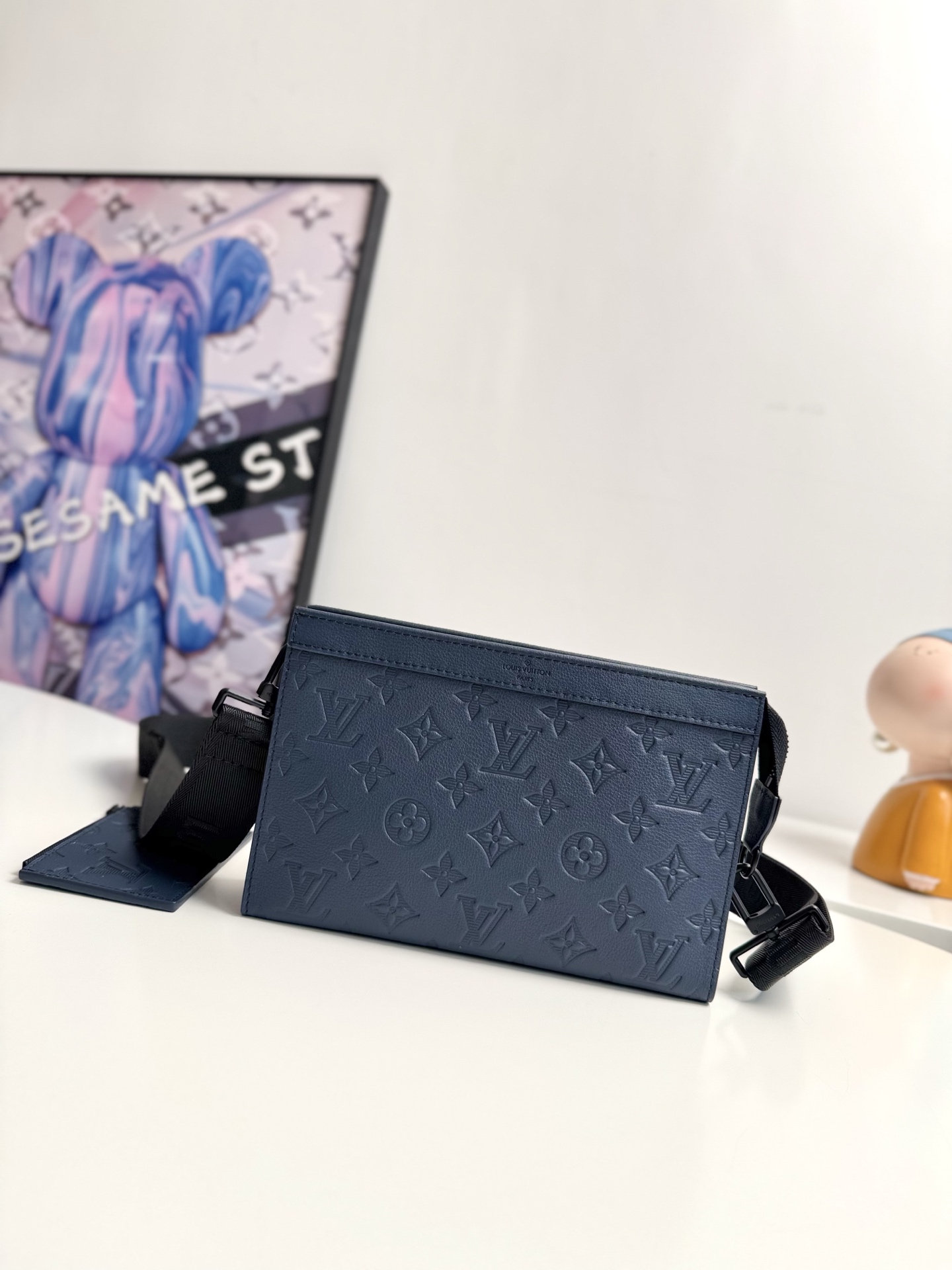 海外原单M81115深蓝独家实拍  Gaston Wearable Wallet 手袋脱胎于路易威登 Pochette Voyage 手拿包 以 Monogram Shadow 皮革裁出适宜尺寸 可容纳手机等出行所需 可拆卸并调节的肩带配有可拆卸卡夹 是放置免触支付设备或交通卡的理想之所 尺寸 22 14.5 4.5cm
